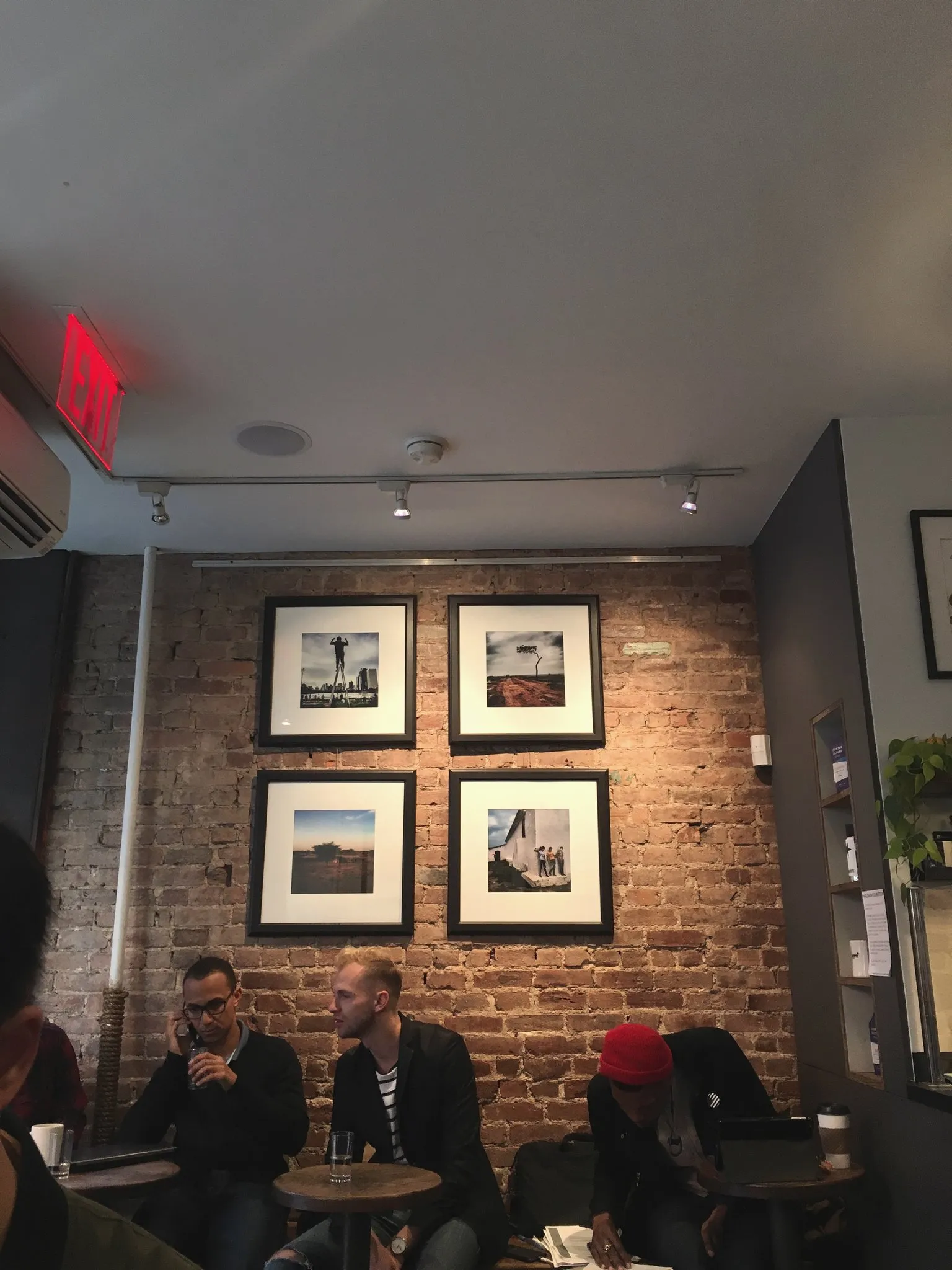 Framed artwork on a café brick wall
