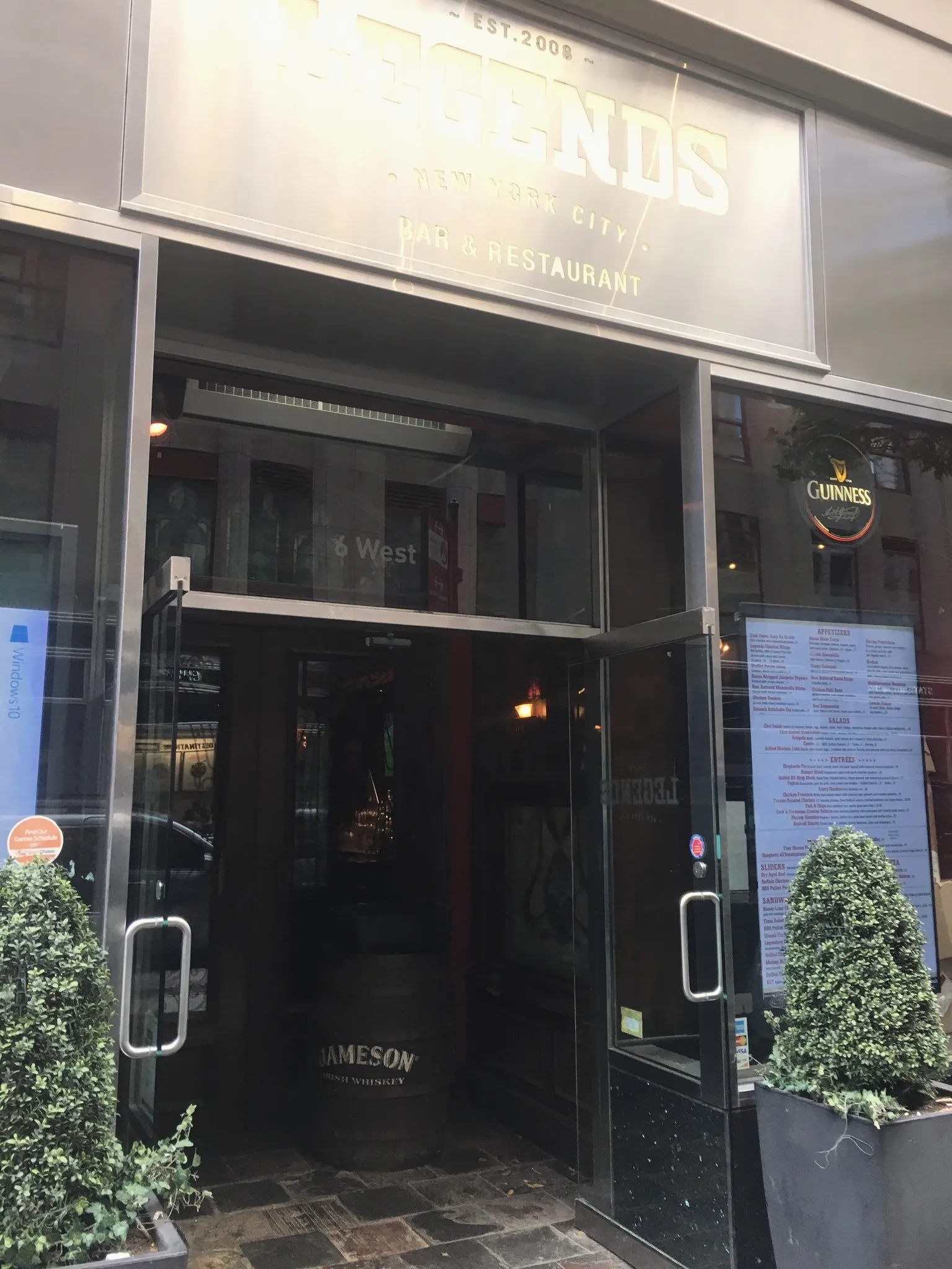 A New York cafe storefront with a wooden bench outside