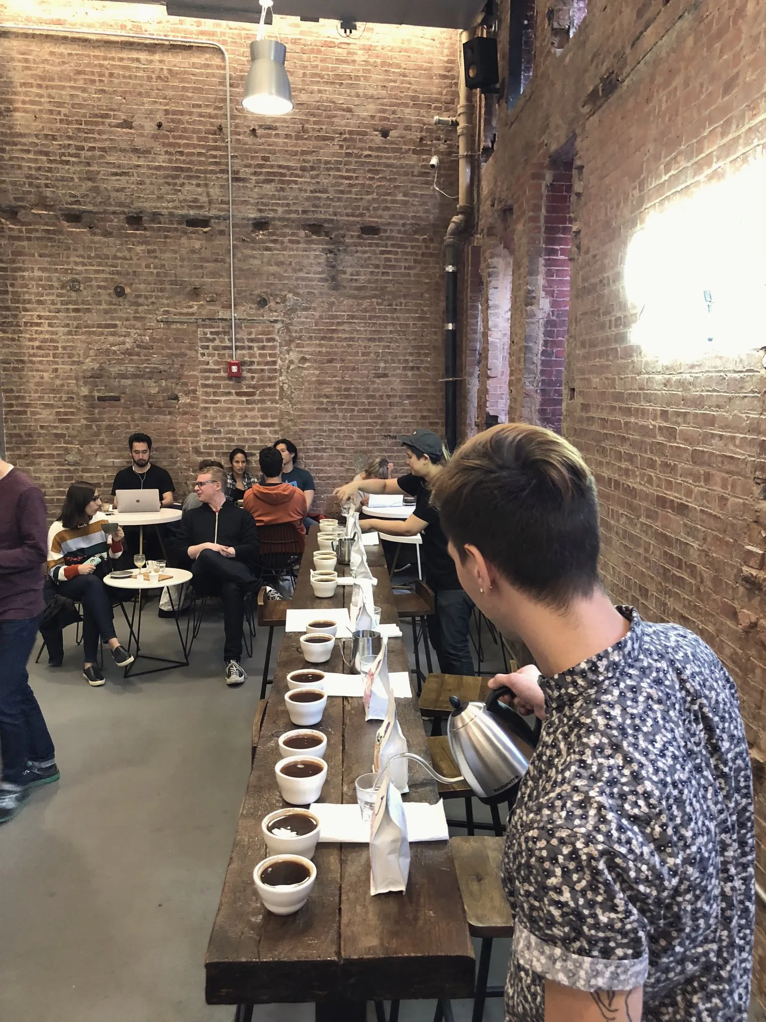 Tasting coffee with a cupping spoon at a festival table